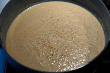 Ghee and wheat flour mixture bubbling in pan.