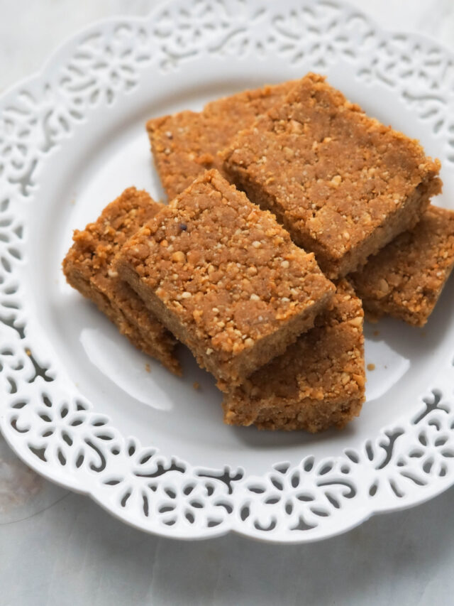 Sing pak or peanut burfi squares on a white laced plate.