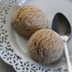 Chikoo ice cream scoops on a white plate with a spoon to the side.