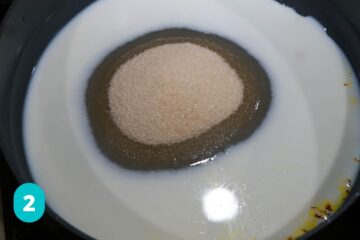 Sugar added to milk in pan.