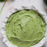 Avocado chutney in a white bowl with cilantro and avocado.