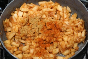Chopped apples with spices in a pan.