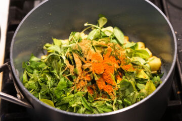 Fenugreek leaves and spices added to pot.