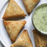 Crispy frozen cocktail samosas with samosa sauce.