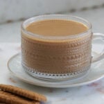 Biscoff chai in a mug with biscoff cookeis to the side.