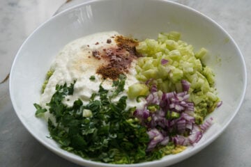 Avocado raita ingredients in a white bowl.