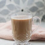 Oat milk chai in a mug with cookies on the side.