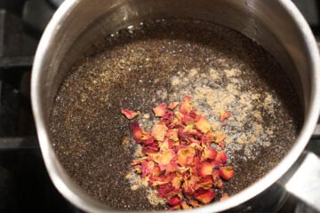 Tea, rose petals, sugar and water in a pot.