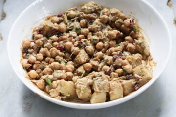 Yogurt mixed in with other chaat ingredients in a white bowl.