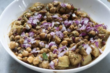 Red onions chopped finely layered on the aloo chana chaat.