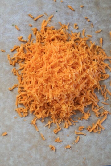 Shredded carrots on a cutting board.