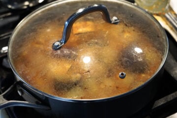 Covered pot cooking on stove top.