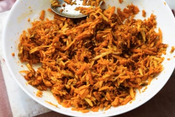 Achaari turmeric root pickle in a white bowl.