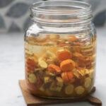 Fresh turmeric root pickle in a glass jar.
