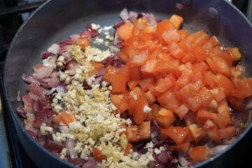 Garlic and tomatoes added to pan.