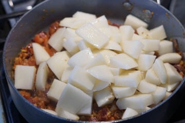 Cubed potatoes added to pan.