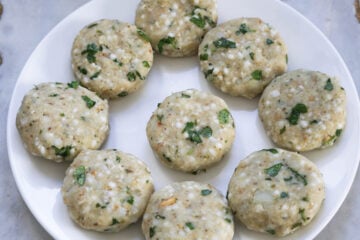 Sabudana vada made into patties on a white plate.
