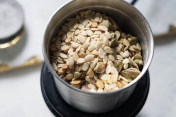 Almonds, cashews, pistachios, and watermelon seeds in a spice grinder.