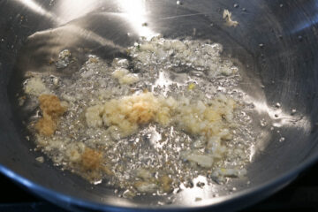 Heated oil with garlic and ginger in a pan.