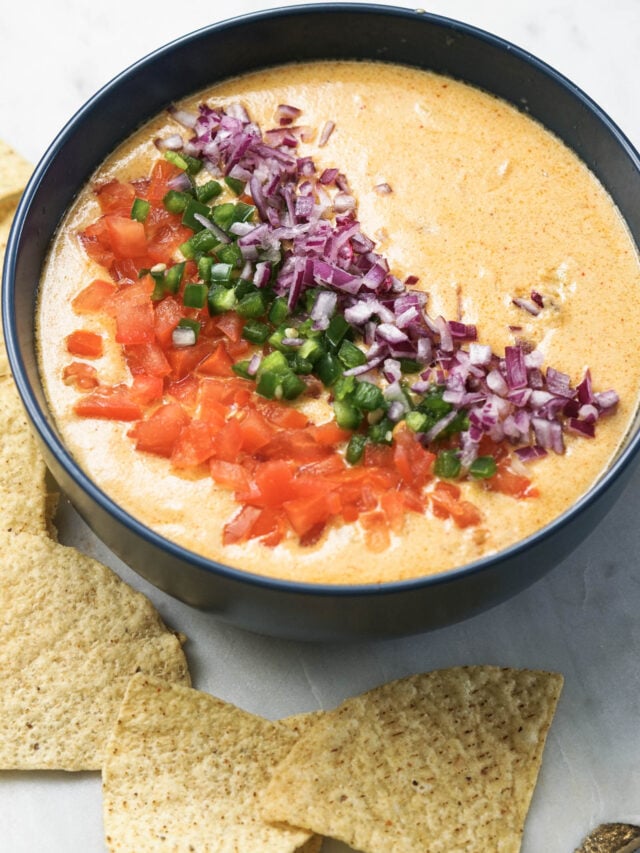 Tandoori queso, an Indian cheese dip topped with onions, tomatoes and jalapenos.