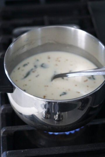 Kadhi yogurt mixture in a pot on stove.