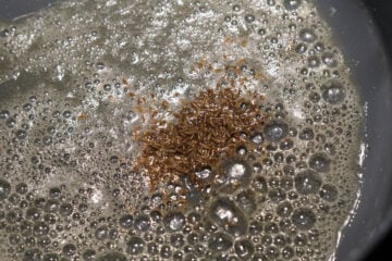 Cumin seed tadka in butter in a pan.