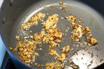 Oil, cumin seeds, garlic, and ginger in a pan.