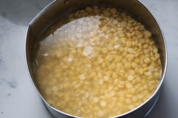 Toor dal soaked in water in a bowl.