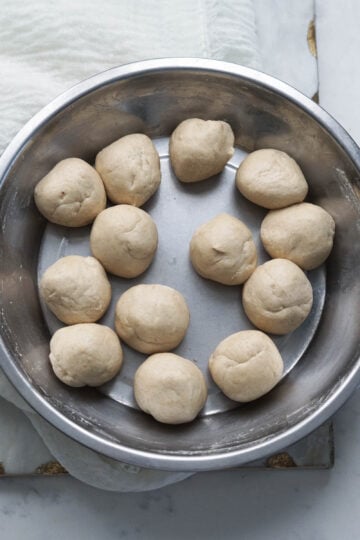 13 dough balls in a steel plate.