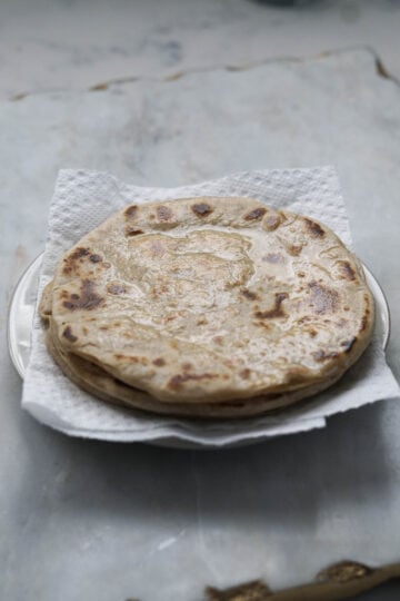 Ghee on puran poli on a plate.
