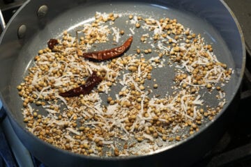 Dry roasting spices and desiccated coconut in pan.