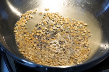 Urad dal, chana dal, and mustard seeds in oil.
