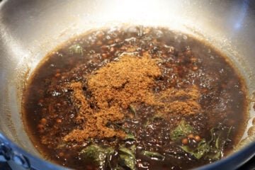 Tamarind concentrate and jaggery powder added to pan.