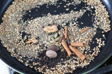 Mace, nutmeg, cinnamon sticks, cardamom (green and black) pods, and black peppercorn added to pan for dry roasting.