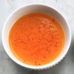 Saffron water in a small bowl.