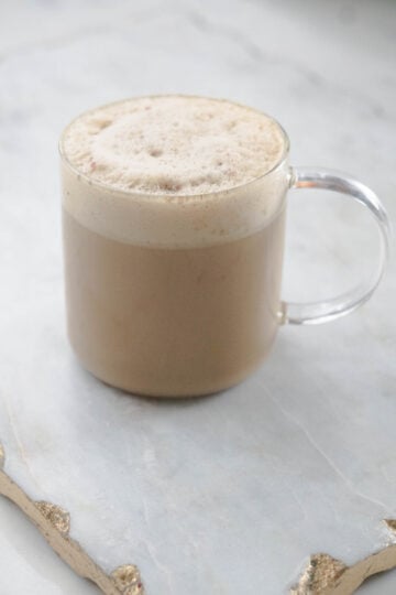 Cardamom latte in a glass mug.