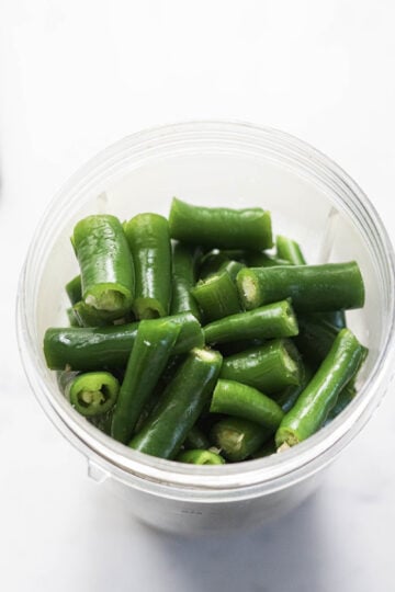 Green chili pieces in a Nutribullet jar.