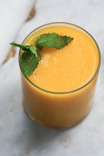 Mango juice in glass with mint leaves.
