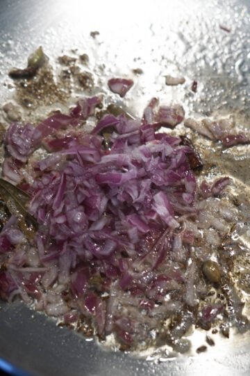 Finely chopped red onions added to ghee.