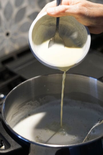 Custard powder slurry poured into milk.