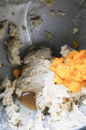 Mango pieces and vanilla extract added to bowl.