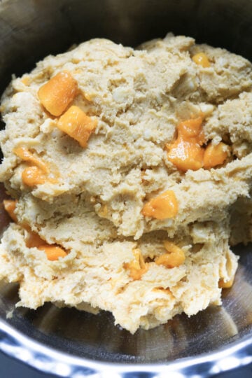 Fresh mango pieces in cookie dough.