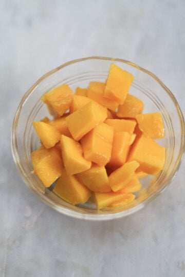 Mango pieces in a glass bowl.