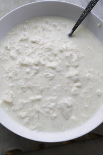 Mashed rice with yogurt and milk in a bowl.