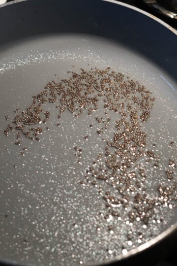 Mustard seeds in oil in pan.