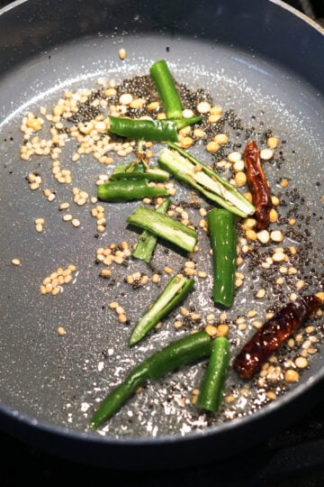 Green chilies and dry red chilies added to tempering.