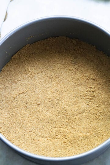 Graham cracker crust in a springform pan.