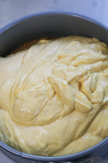 Mango cheesecake batter in a springform pan.