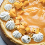 Baked mango cheesecake with mango puree, chopped fresh mangoes, and whipped cream topping.
