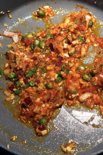 Crushed canned tomatoes added to pan.